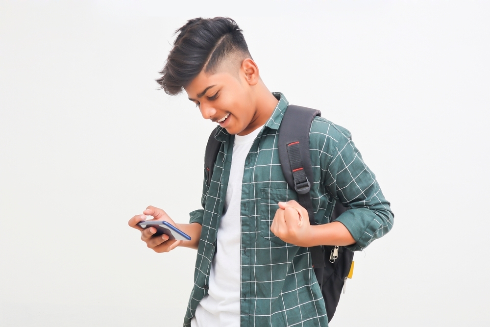Indian,College,Student,Using,Smartphone,On,White,Background.