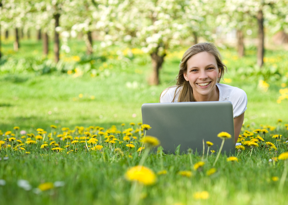 Young,Woman,With,Notebook,In,Park,Looking,At,Camera